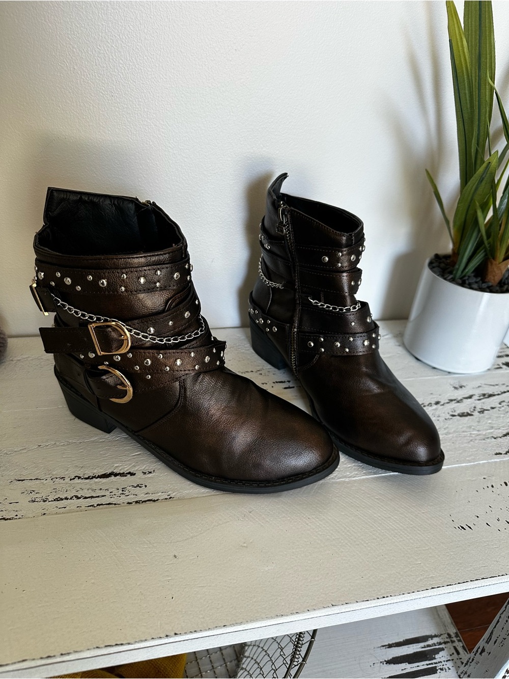 Dark brown belted booties with stud and chain accents